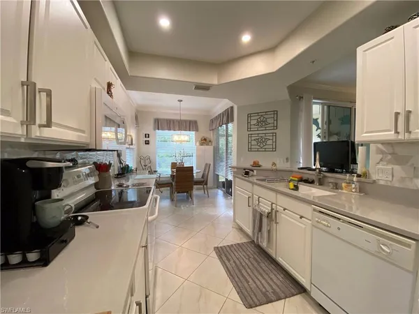 a large white kitchen with a large window