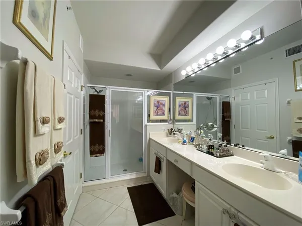 a spacious bathroom with a double vanity sink a large mirror a shower and a bathtub