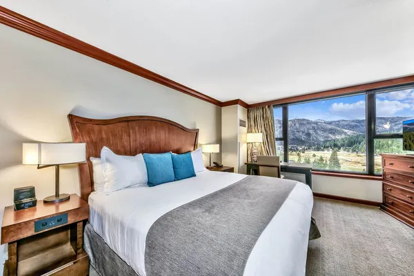 a bedroom with a large bed and a large window with outer view