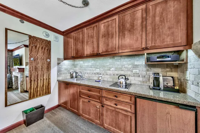 a kitchen with stainless steel appliances granite countertop a sink a stove and a refrigerator with wooden cabinets