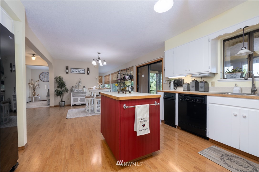 765 Eadon Road Toledo, WA 98591 - Photo 8 of 40 a kitchen with stainless steel appliances granite countertop a stove a sink dishwasher a refrigerator and a dining table with wooden floor
