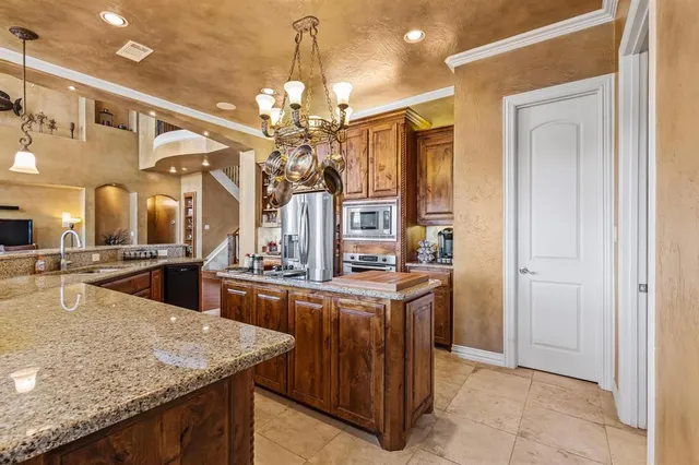 a kitchen with stainless steel appliances granite countertop a sink and a refrigerator