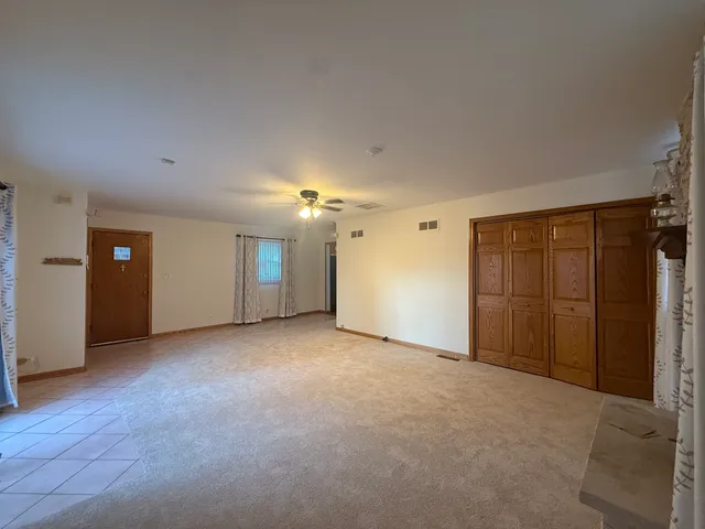 an empty room with closet and windows