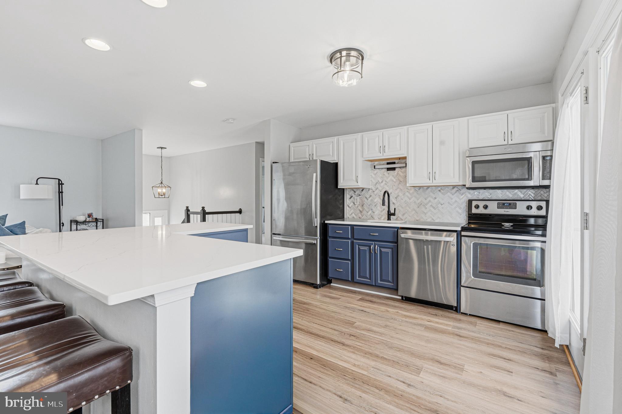 243 9th Street Pasadena, MD 21122 - Photo 13 of 41 a kitchen with kitchen island a sink stove and refrigerator