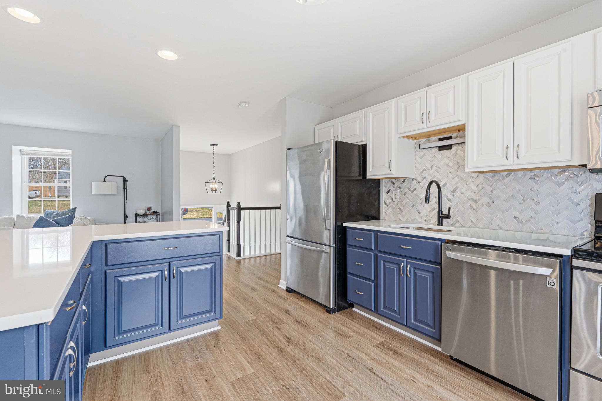 243 9th Street Pasadena, MD 21122 - Photo 14 of 41 a kitchen with stainless steel appliances granite countertop a refrigerator a sink dishwasher and wooden cabinets with wooden floor