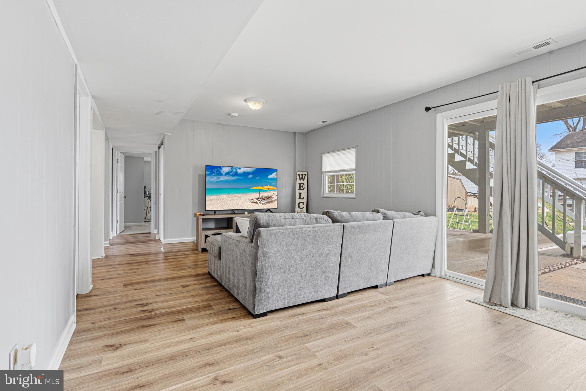 243 9th Street Pasadena, MD 21122 - Photo 30 of 41 a living room with furniture a flat screen tv and a floor to ceiling window