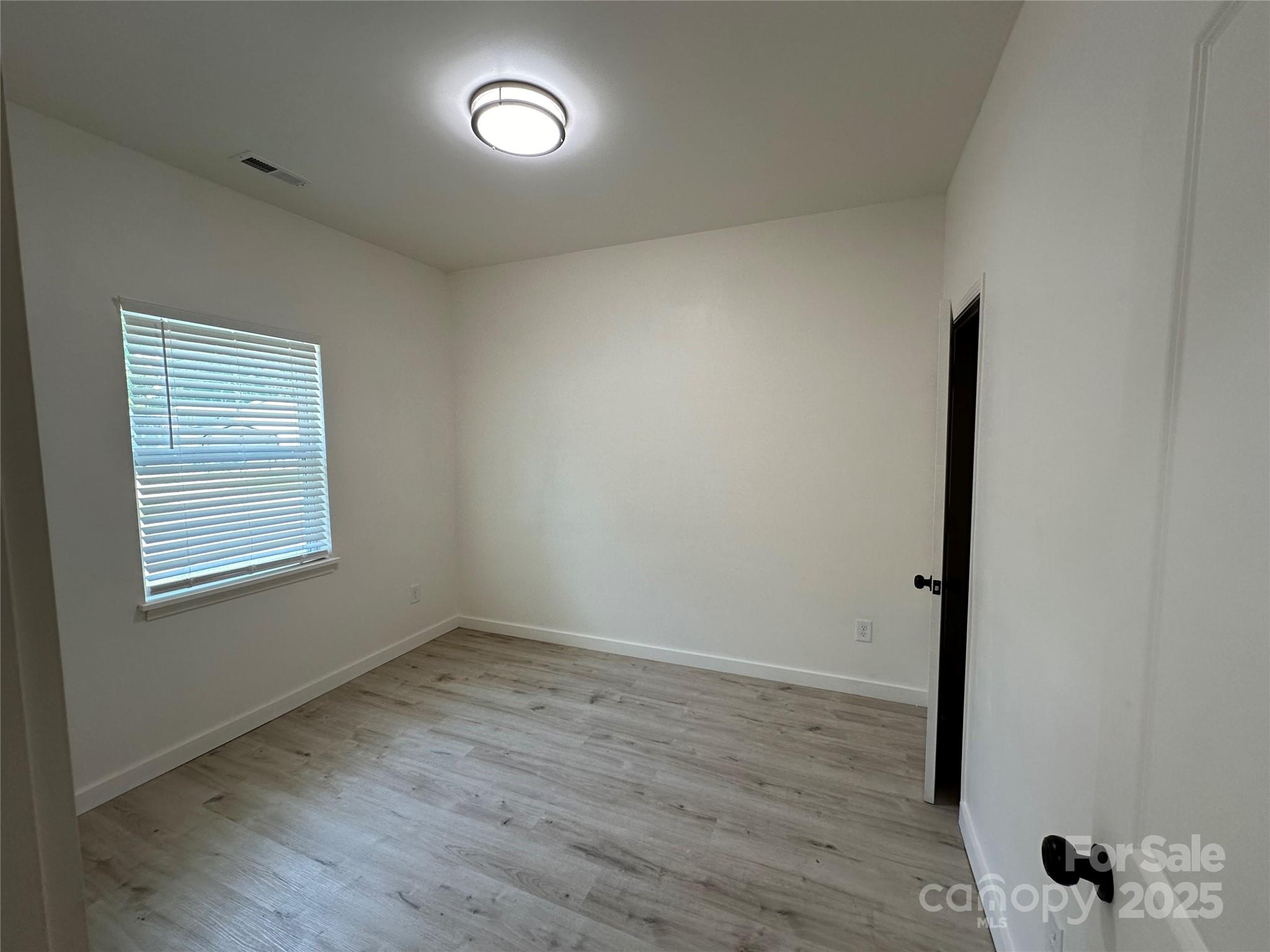1409 Enochville Road Kannapolis, NC 28081 - Photo 3 of 14 an empty room with wooden floor and windows