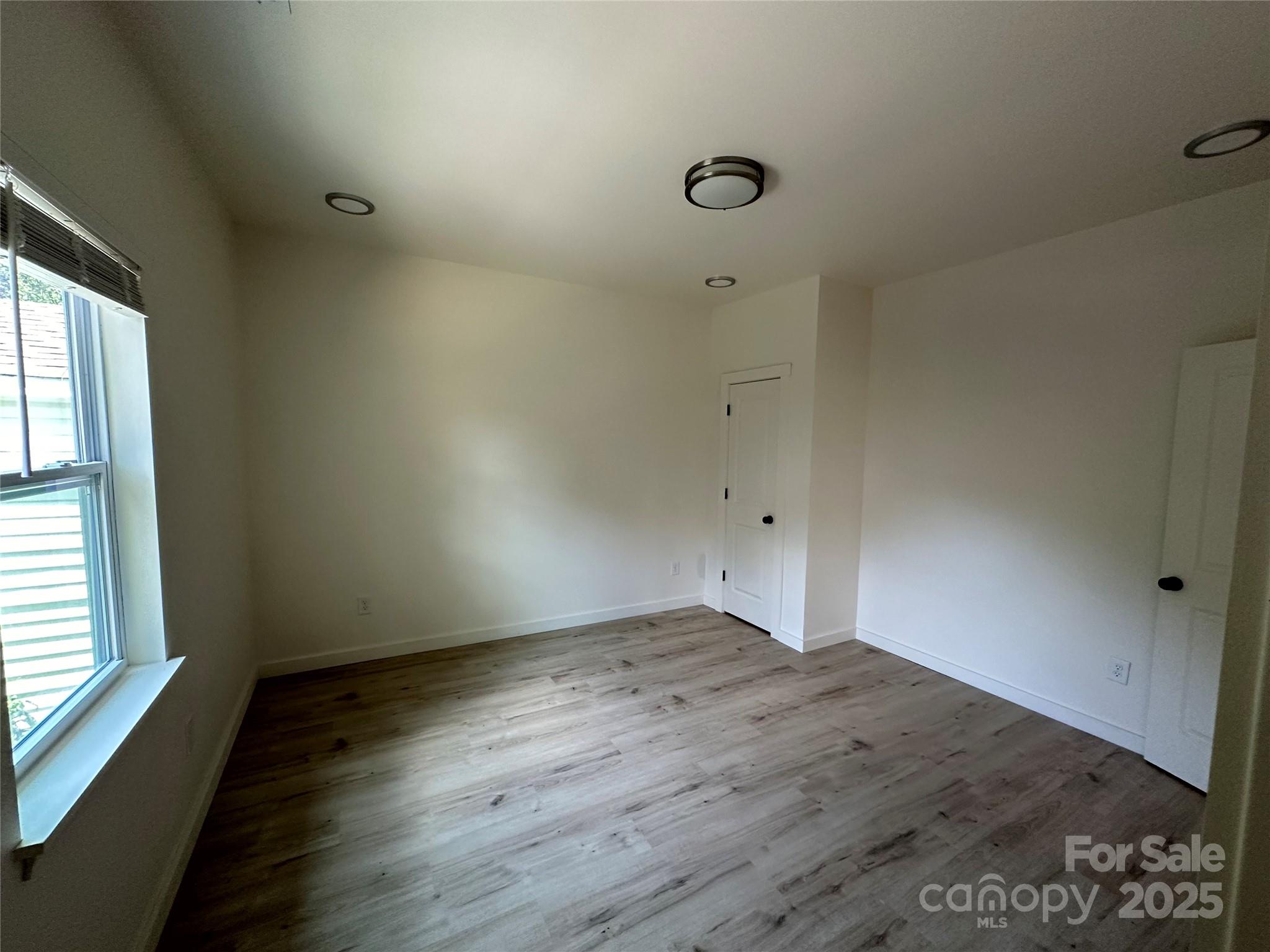1409 Enochville Road Kannapolis, NC 28081 - Photo 9 of 14 an empty room with wooden floor and windows