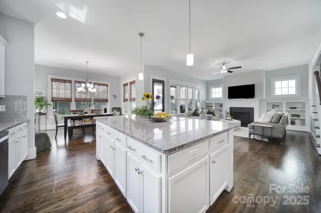 a kitchen with stainless steel appliances granite countertop counter space a sink and a living room