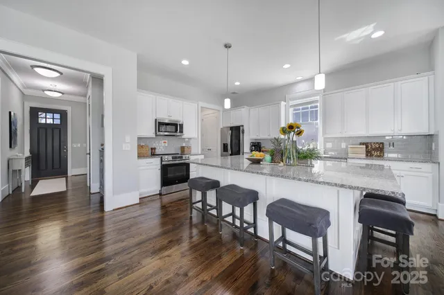 a kitchen with a table chairs microwave and cabinets
