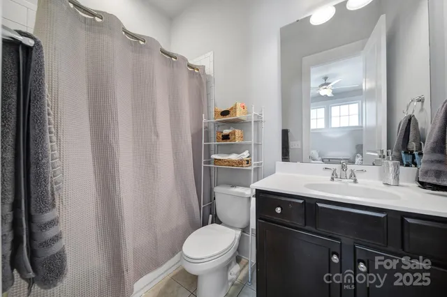 a bathroom with a granite countertop sink toilet and mirror