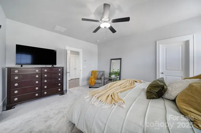 a bedroom with a bed and a flat tv screen on dresser