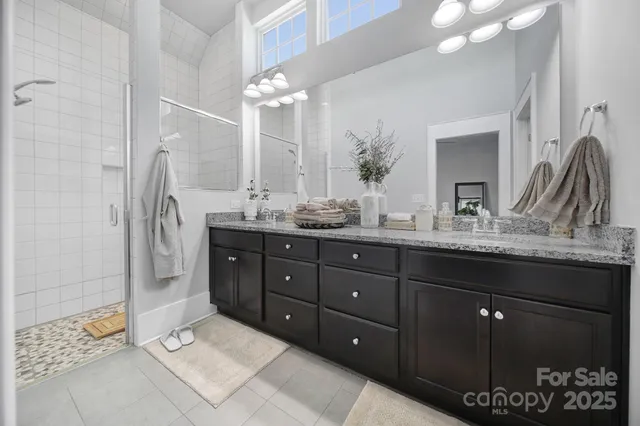 a spacious bathroom with double vanity and a mirror