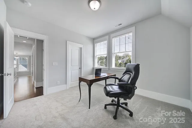 a view of a workspace with furniture and a window