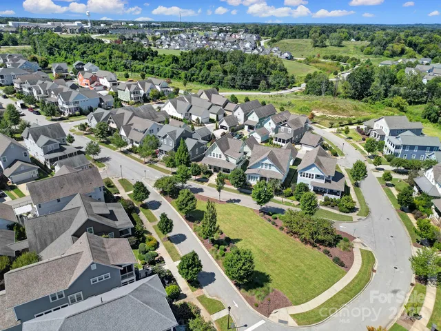 an aerial view of residential houses with outdoor space and street view