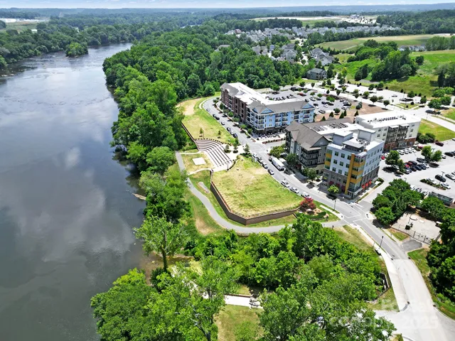 an aerial view of a house with a garden and lake view