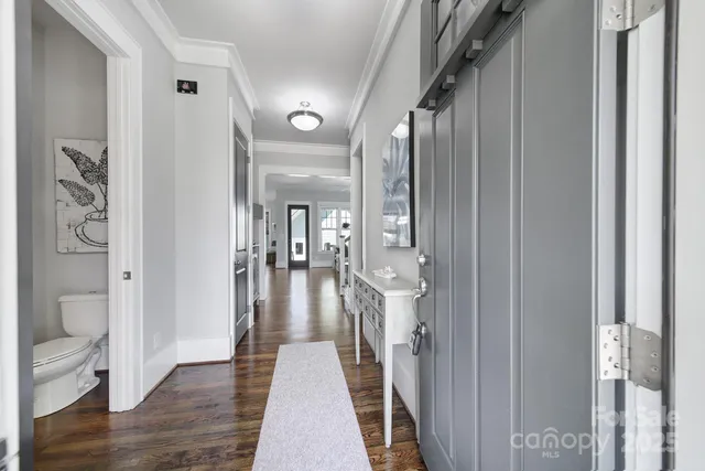 a view of a hallway with wooden floor and staircase