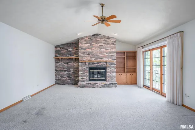 a view of an empty room with a fireplace and a window