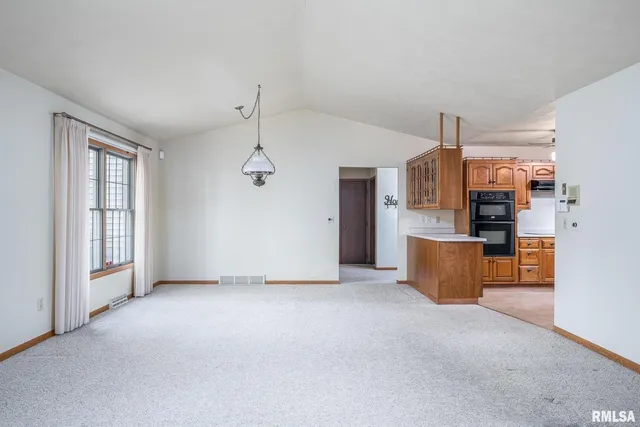 a view of a kitchen with refrigerator and windows