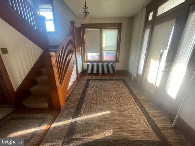 a view of a hallway with furniture and a bathroom
