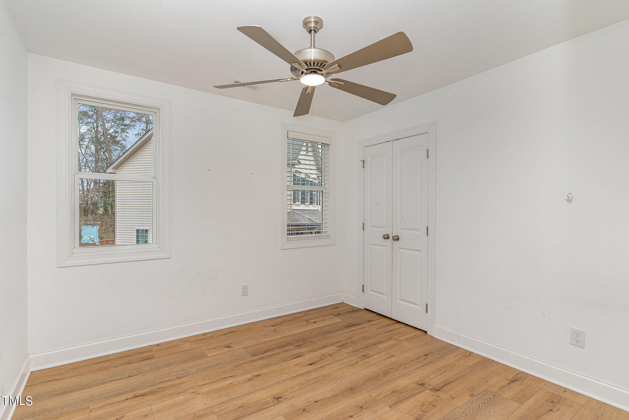 125 Holyoke Court Raleigh, NC 27603 - Photo 17 of 30 a view of an empty room with wooden floor and a ceiling fan