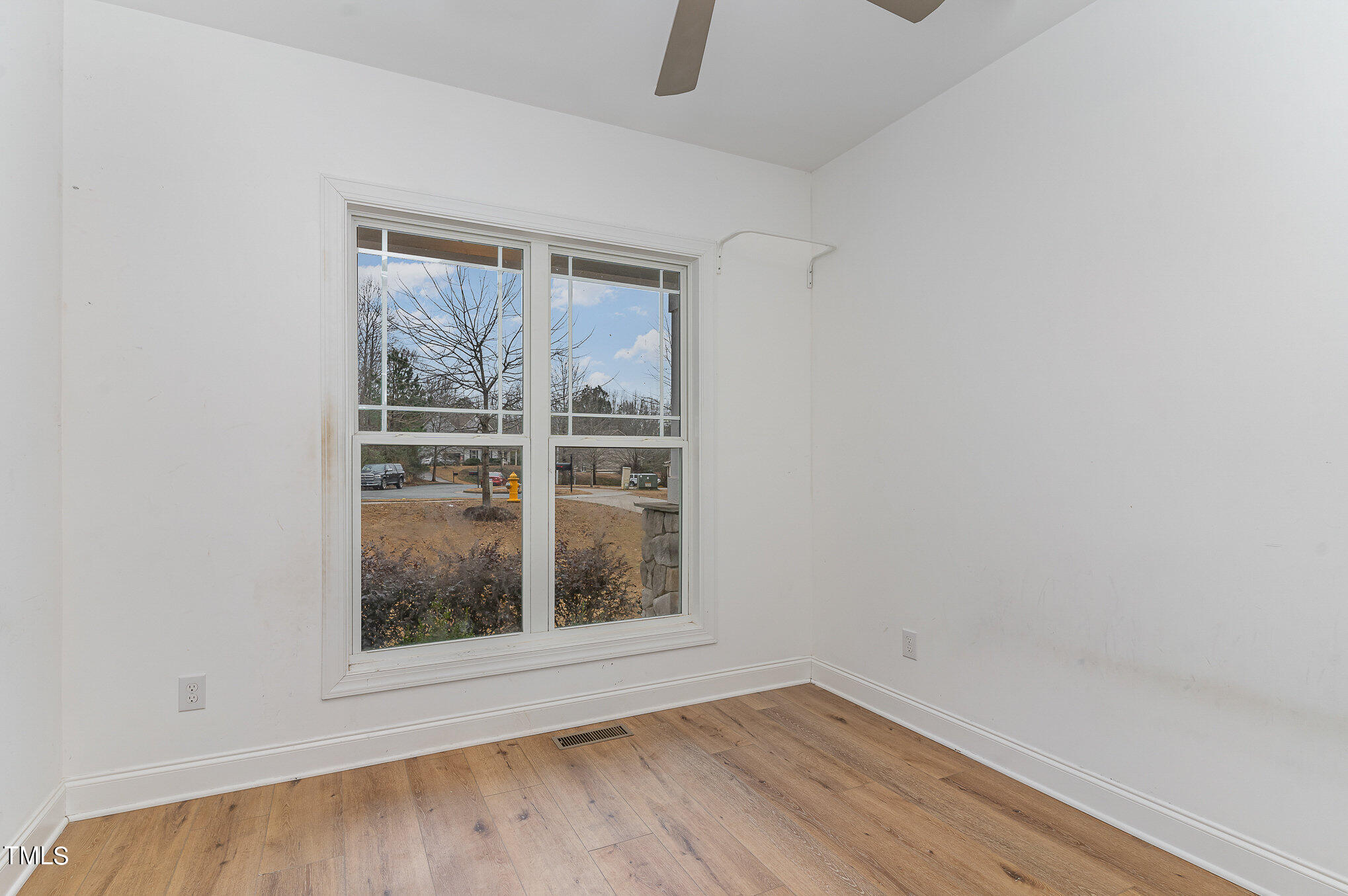 125 Holyoke Court Raleigh, NC 27603 - Photo 7 of 30 a view of an empty room with wooden floor and a window