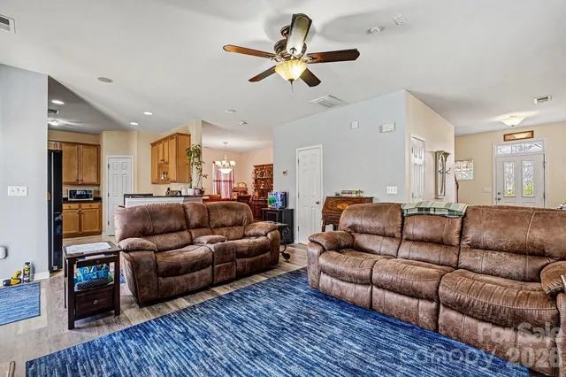 a living room with furniture ceiling fan and a rug