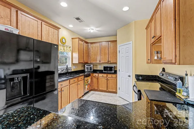 a kitchen with stainless steel appliances granite countertop a sink a stove and a granite counter tops