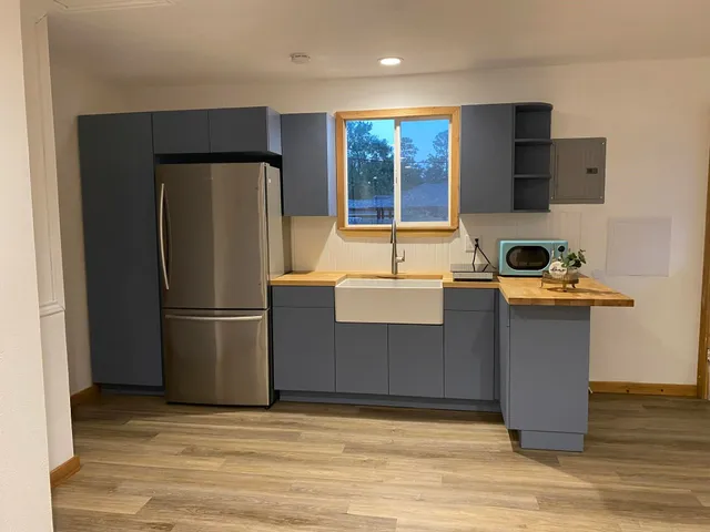 a kitchen with stainless steel appliances granite countertop a refrigerator a stove a sink dishwasher and a refrigerator with wooden floor