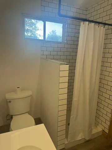 a bathroom with a toilet and a shower