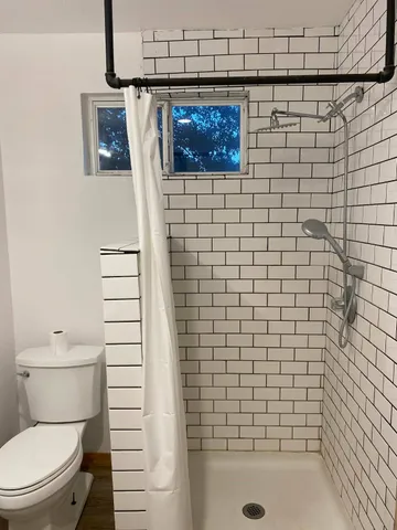 a bathroom with a toilet and a shower