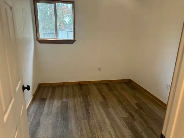 a view of a small space with wooden floor and a window