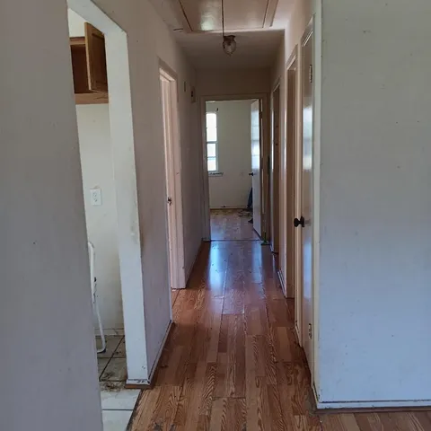 a view of a hallway with wooden floor