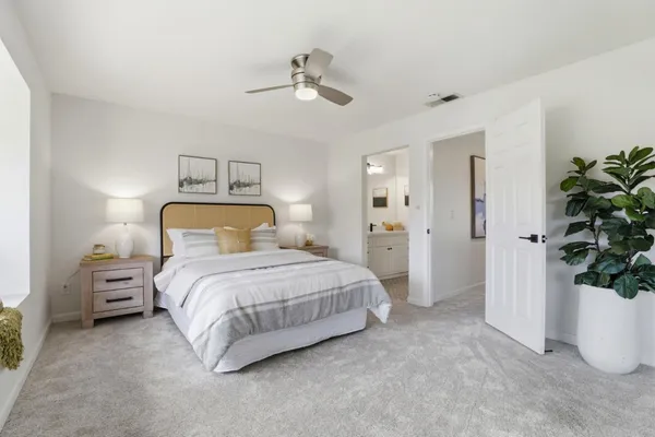 a bedroom with a bed and a potted plant