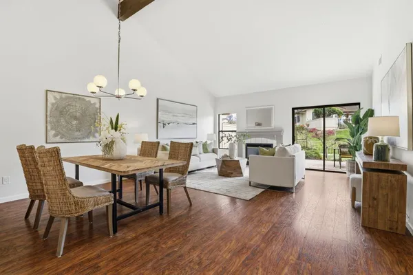 a dining room with furniture a chandelier and wooden floor