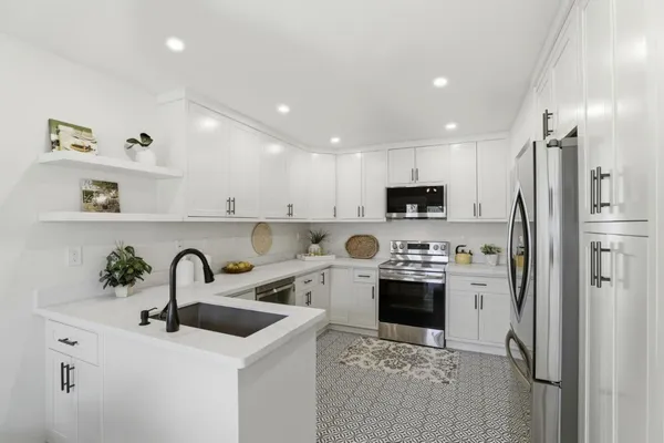 a kitchen with sink a refrigerator and cabinets