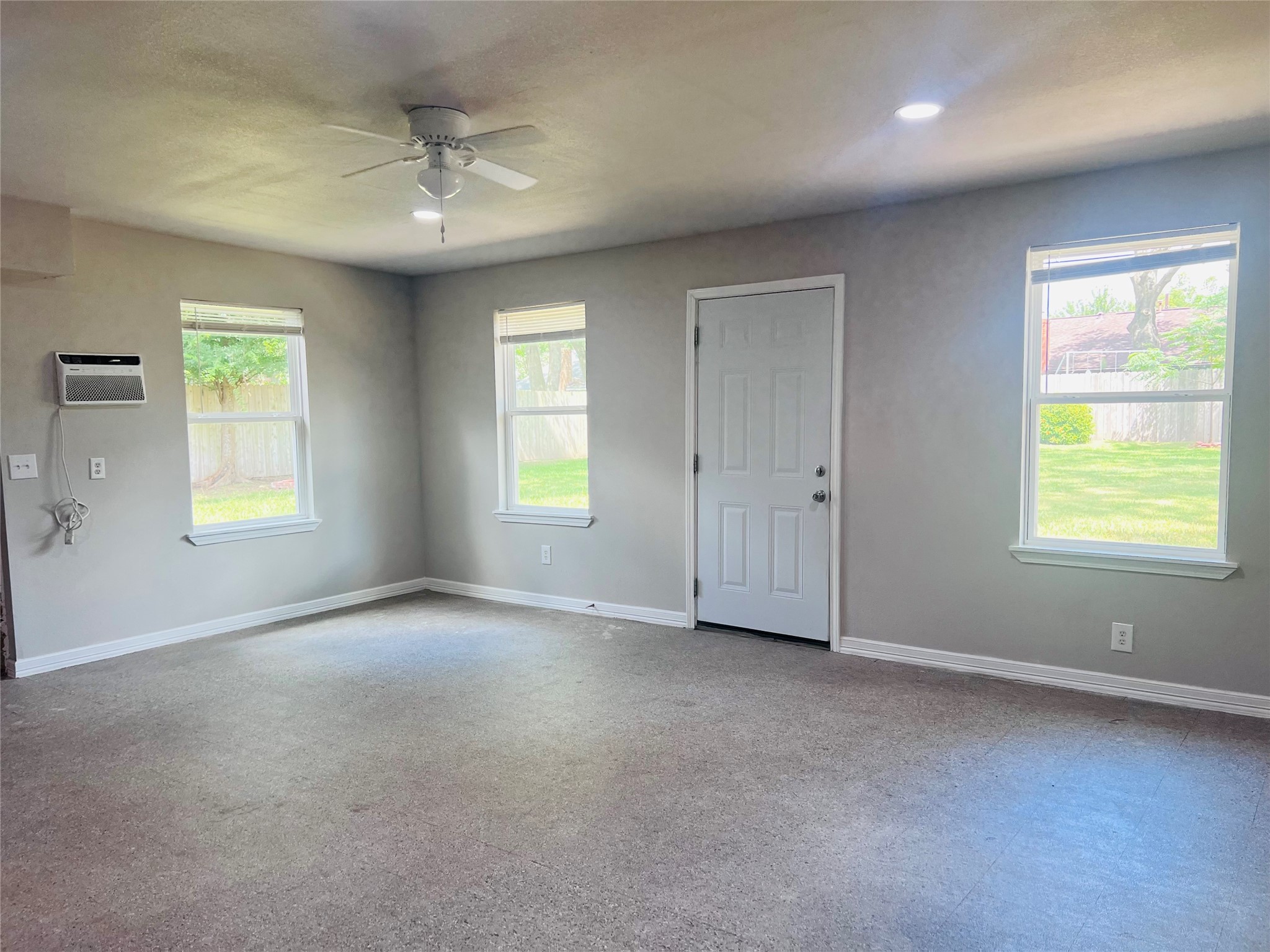 902 Hidden Canyon Road Katy, TX 77450 - Photo 15 of 20 HUGE GAME ROOM BUILT ON BEHIND GARAGE CAN BE USED AS A FOURTH BEDROOM with A/c Window, neutral walls, a ceiling fan, and large windows overlooking a fenced backyard.