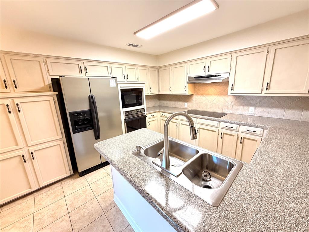 2018 Tree House Lane Plano, TX 75023 - Photo 7 of 15 a kitchen with stainless steel appliances granite countertop a sink refrigerator and microwave