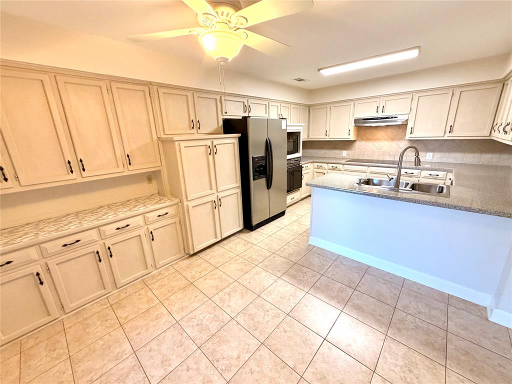 2018 Tree House Lane Plano, TX 75023 - Photo 8 of 15 a kitchen with stainless steel appliances granite countertop a refrigerator sink and cabinets