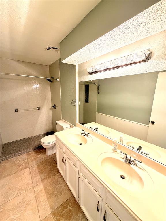 2018 Tree House Lane Plano, TX 75023 - Photo 9 of 15 a spacious bathroom with a double vanity sink mirror and toilet