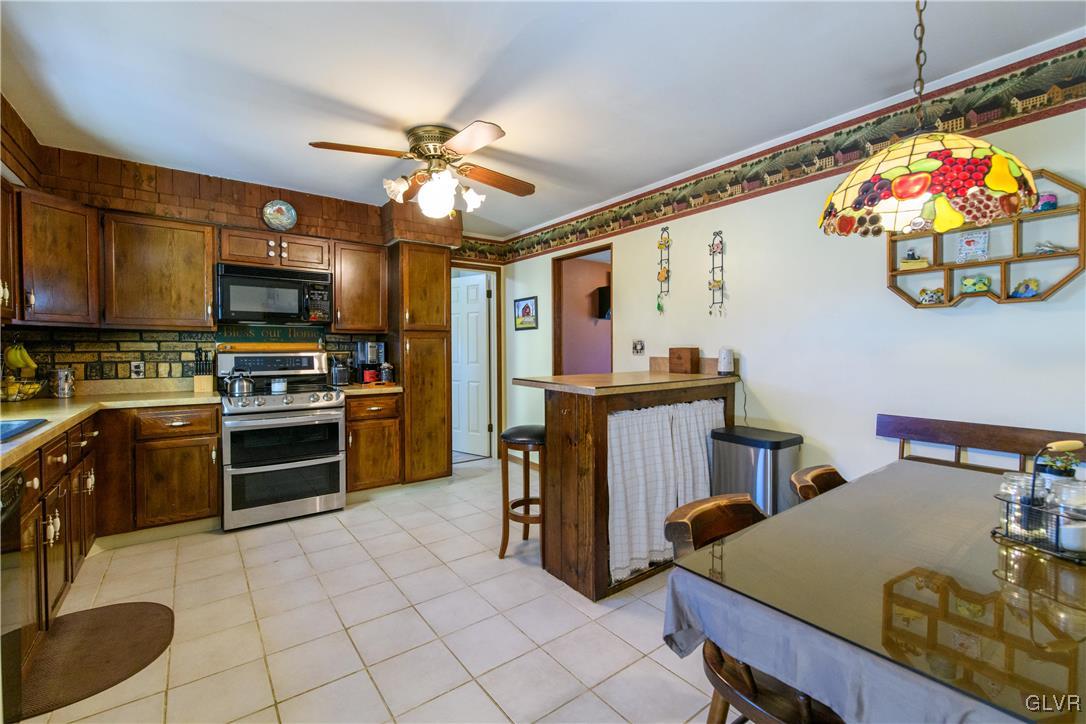 3 Koeck Road Columbia, NJ 07832 - Photo 10 of 23 a kitchen with stainless steel appliances granite countertop a stove top oven a sink a dining table and chairs with wooden floor