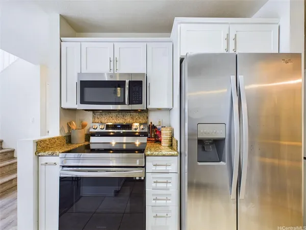 a kitchen with stainless steel appliances a stove microwave and a refrigerator