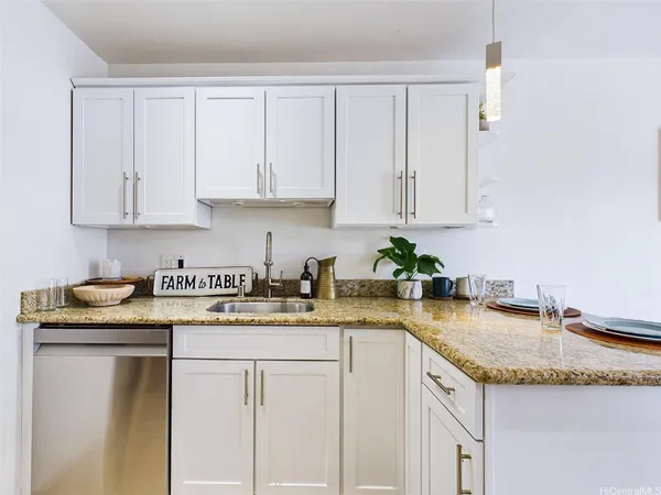 a kitchen with granite countertop white cabinets and a sink