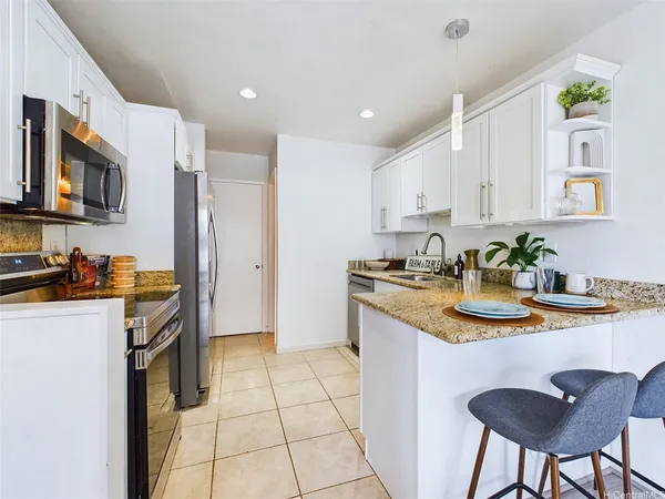 a kitchen with stainless steel appliances granite countertop a sink a stove a refrigerator a microwave oven with a dining table and chairs
