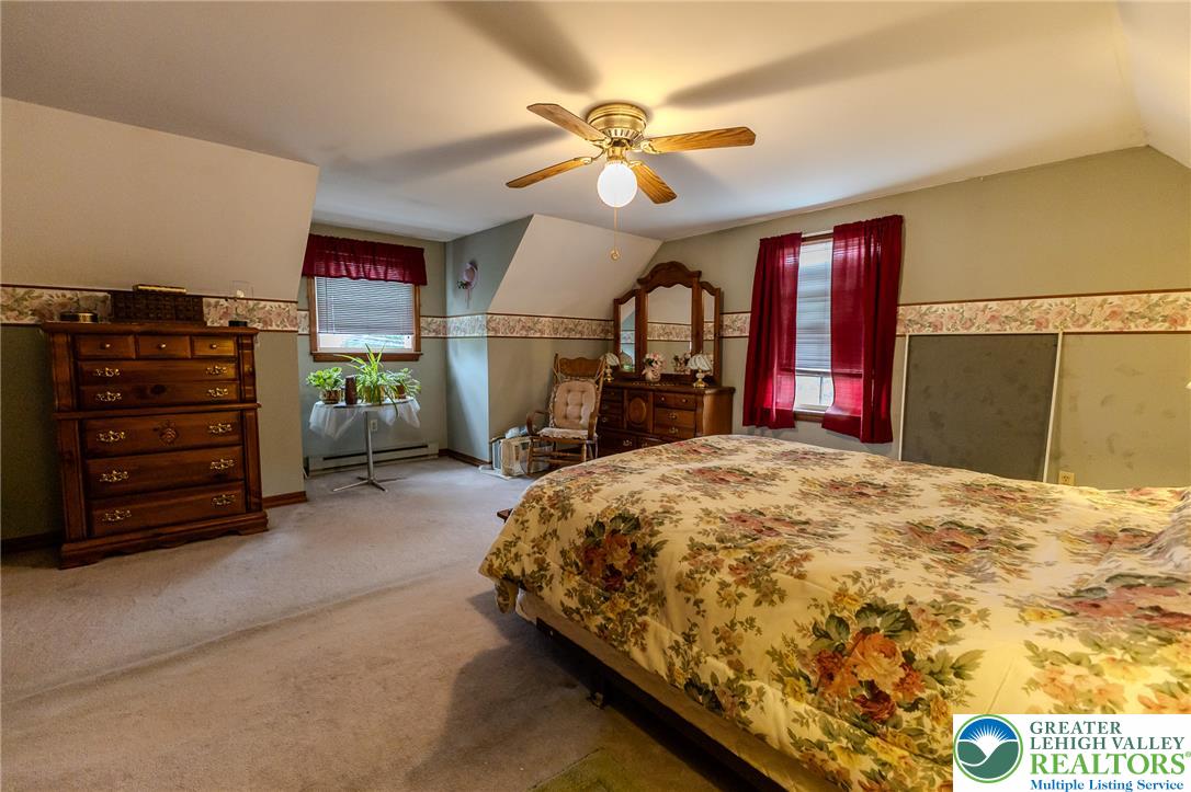 40 Locke Heights Road Bangor, PA 18013 - Photo 23 of 28 A well-lit bedroom features sloped ceilings, soft carpeting, and multiple windows.
