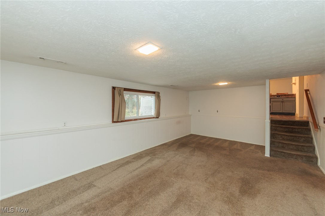 28013 Knickerbocker Road Bay Village, OH 44140 - Photo 27 of 38 Family room featuring a textured ceiling, carpet floors, and stairs