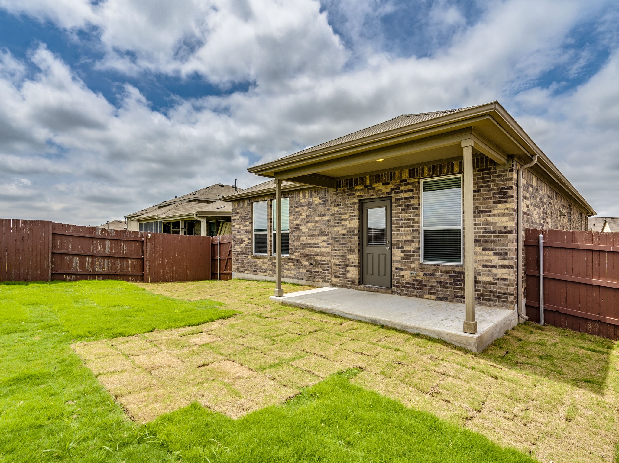 790 Pepperbark Loop Buda, TX 78610 - Photo 20 of 22 A well-maintained backyard boasts a covered patio and sturdy wood fencing, offering a private outdoor retreat.