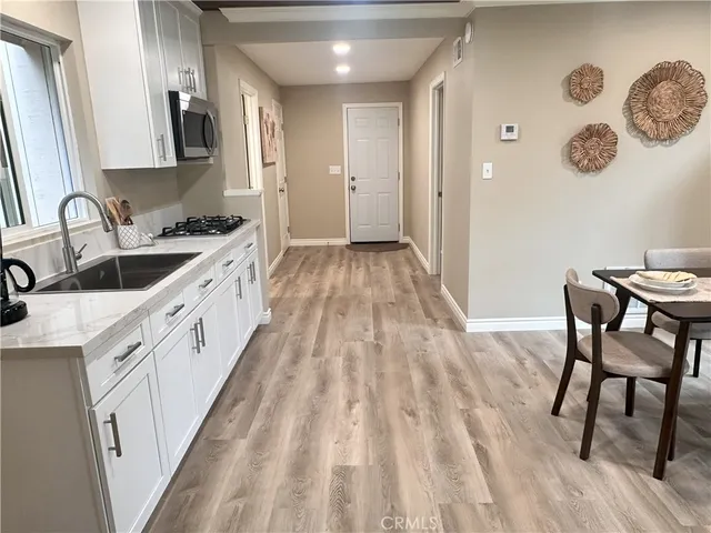 a kitchen with granite countertop white cabinets and sink