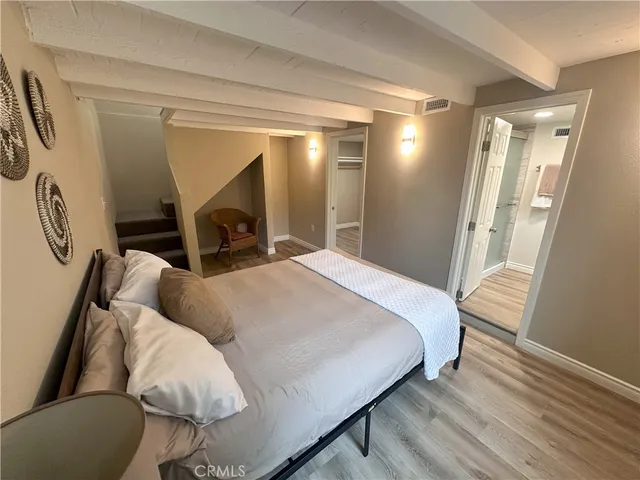 a spacious bedroom with a bed and a mirror