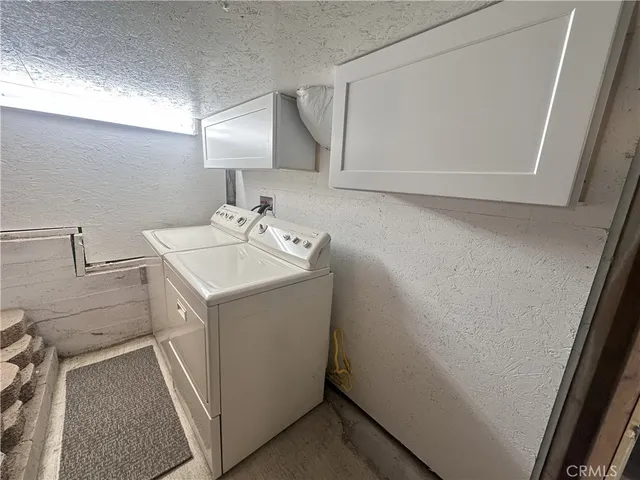 a utility room with cabinets washer and dryer